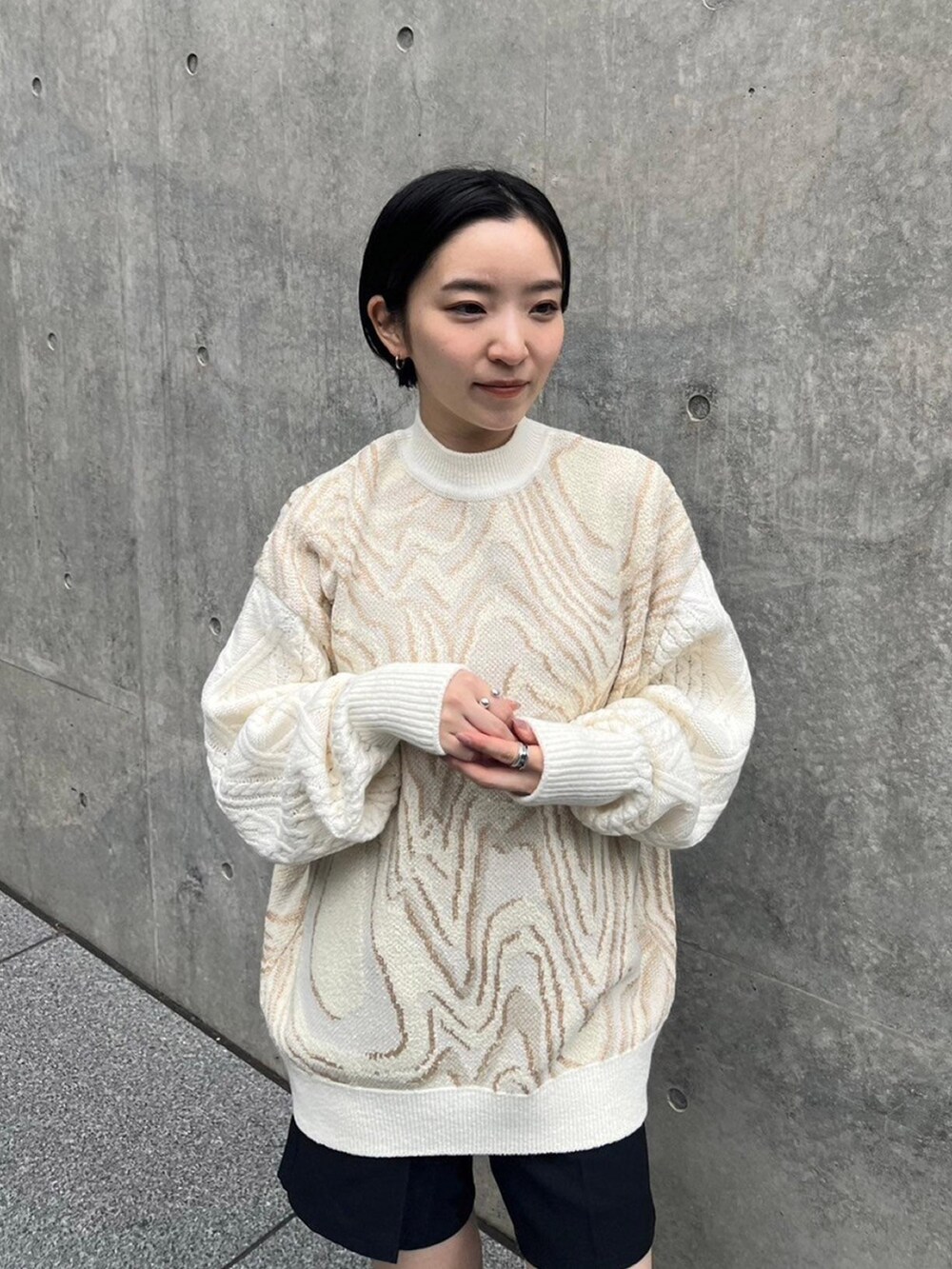 ホワイト系のニット/セーター、ブラック系のその他パンツを着用したレディースの秋コーディネートの4枚目の写真