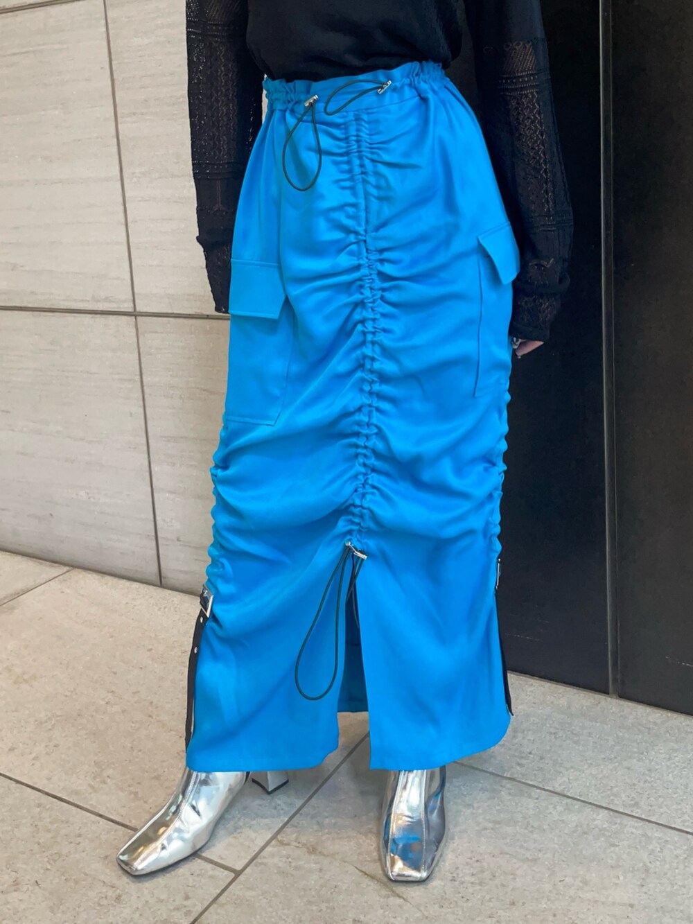 ブラック系のニット/セーター、ブルー系のスカートを着用したレディースの春コーディネートの6枚目の写真