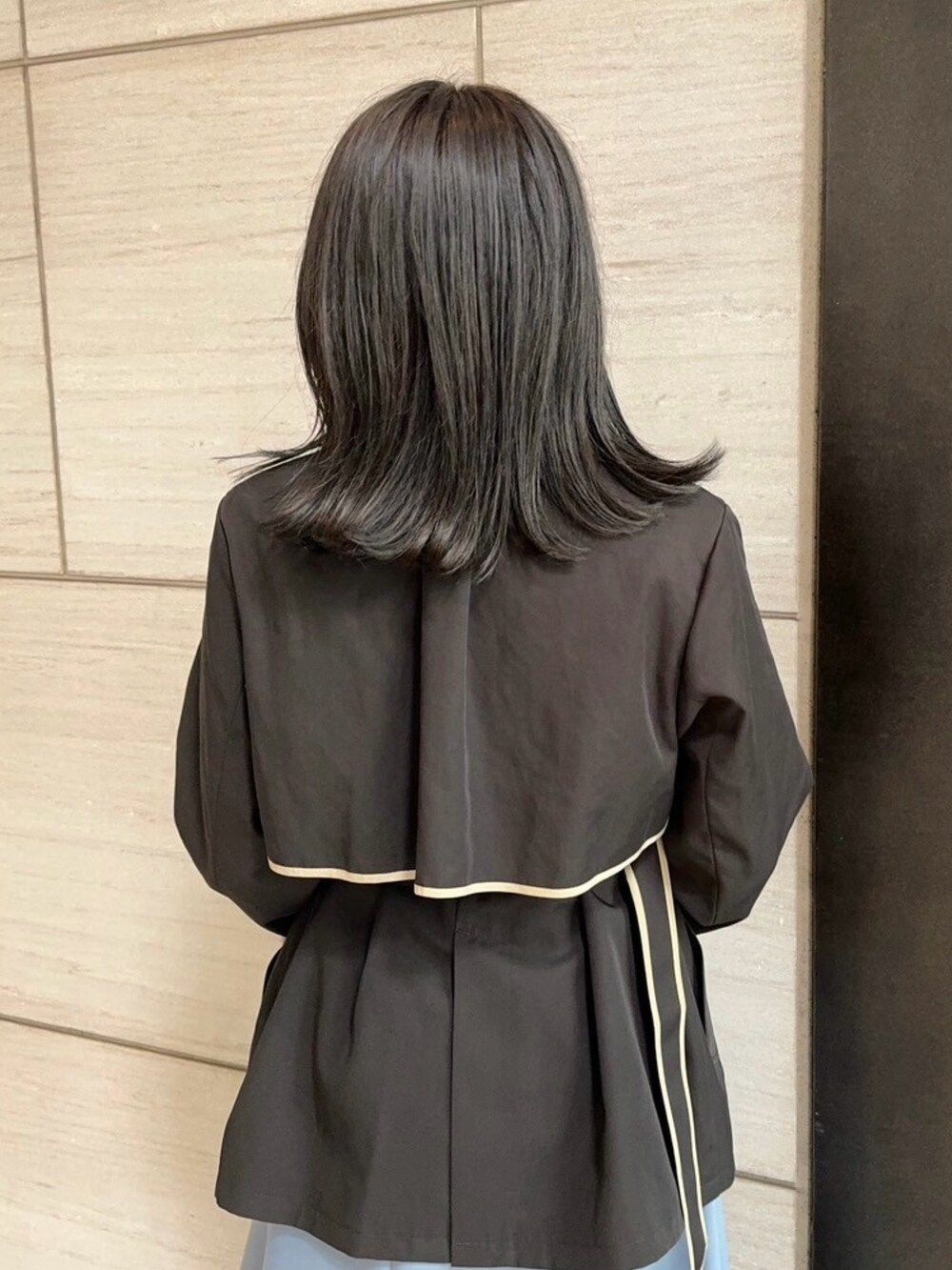 ブラック系のトレンチコートを着用したレディースの春コーディネートの6枚目の写真