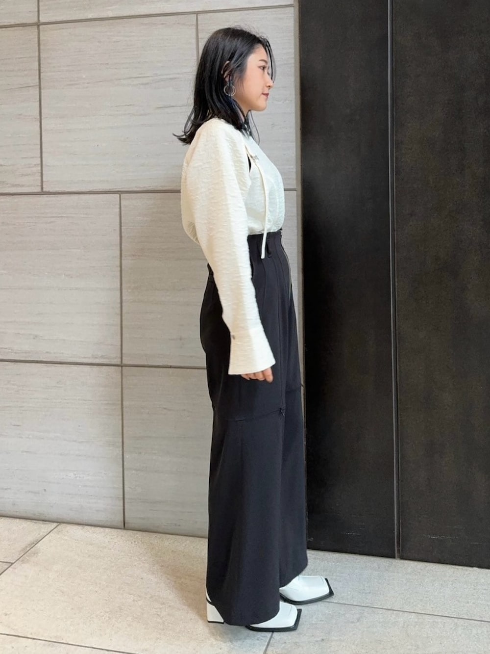 ブラック系のその他パンツ、ホワイト系のシャツ/ブラウスを着用したレディースの春コーディネートの2枚目の写真