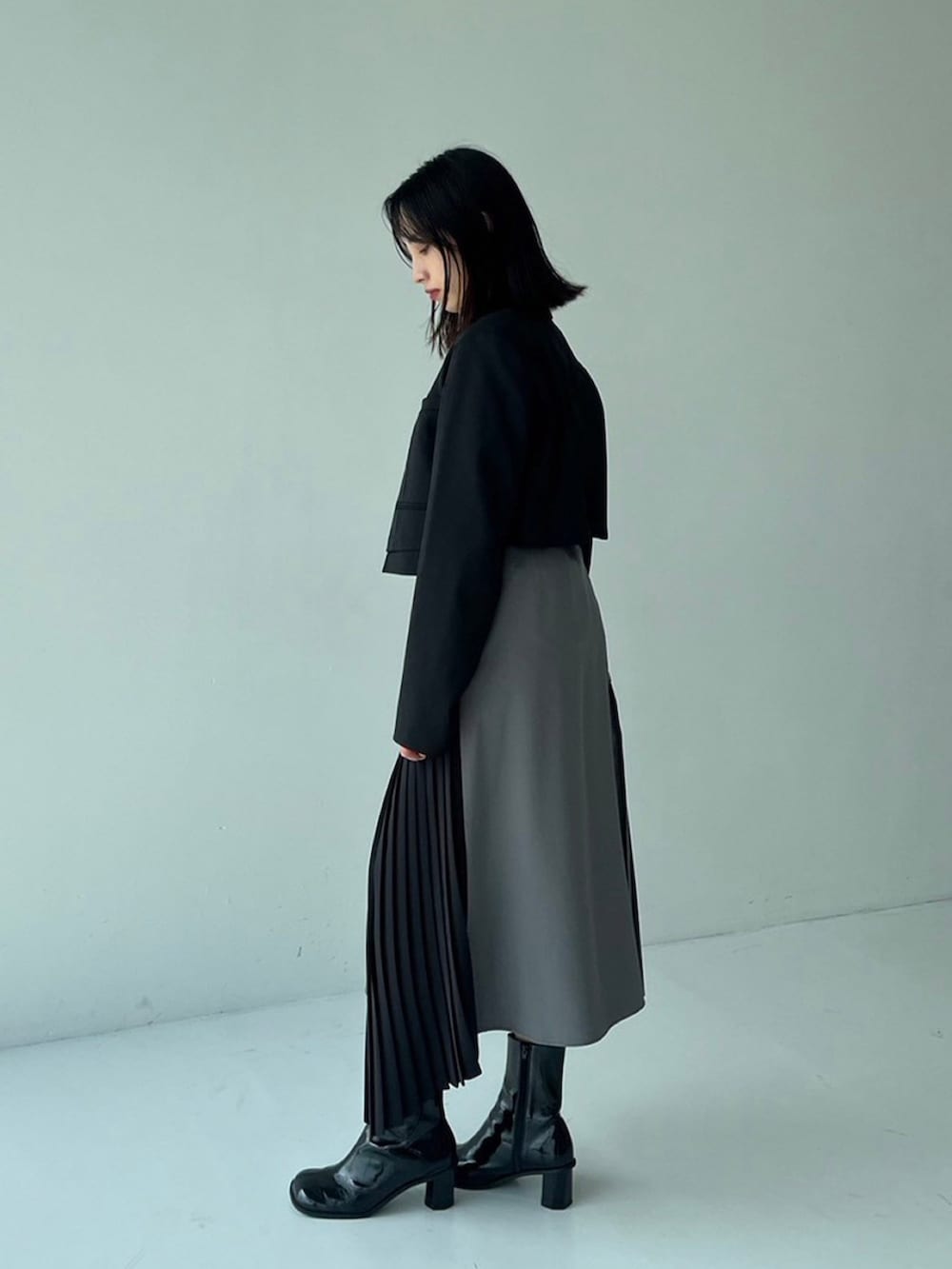 ブラック系のテーラードジャケット、グリーン系のスカートを着用したレディースの秋コーディネートの2枚目の写真