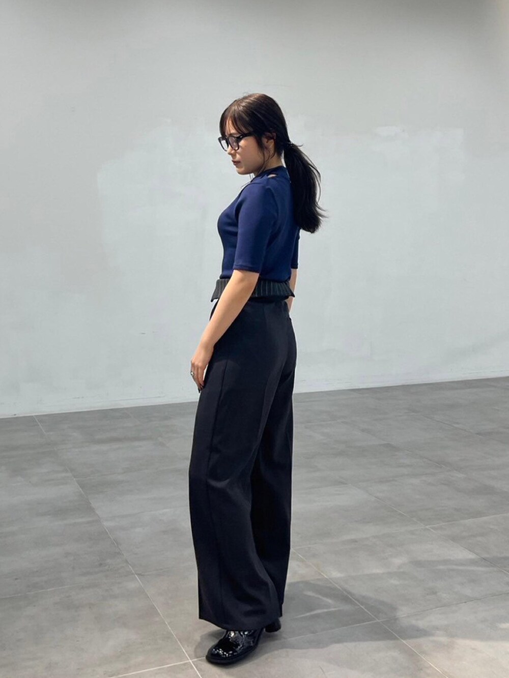 ブルー系のTシャツ/カットソー、グレー系のスラックスを着用したレディースの秋コーディネートの3枚目の写真