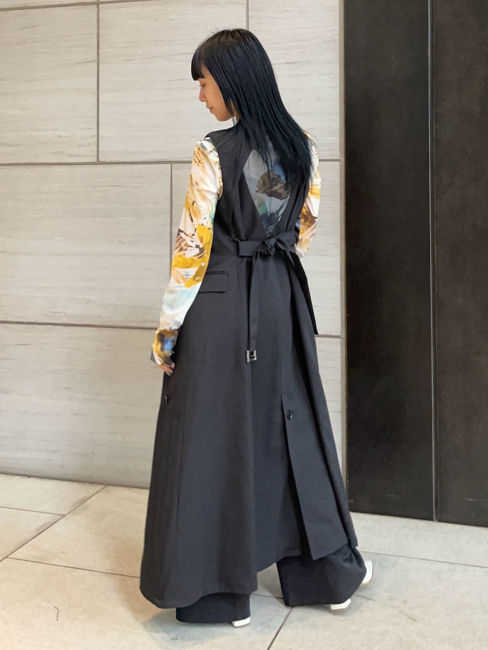 ブラック系のジャンパースカートを着用したレディースの春コーディネートの2枚目の写真