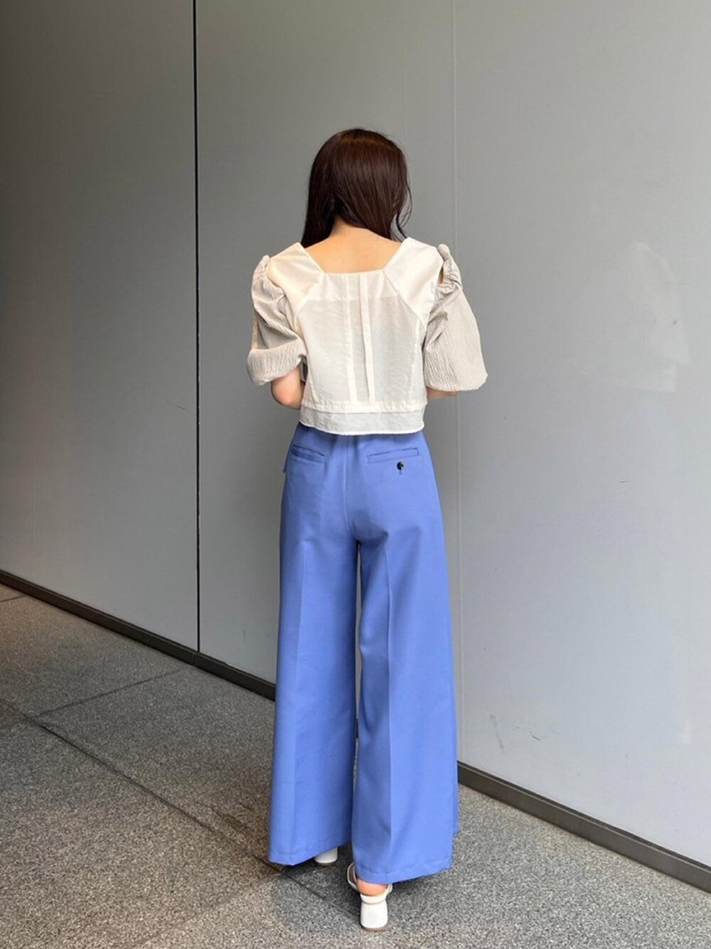 ホワイト系のシャツ/ブラウス、ブルー系のスラックスを着用したレディースの夏コーディネートの3枚目の写真