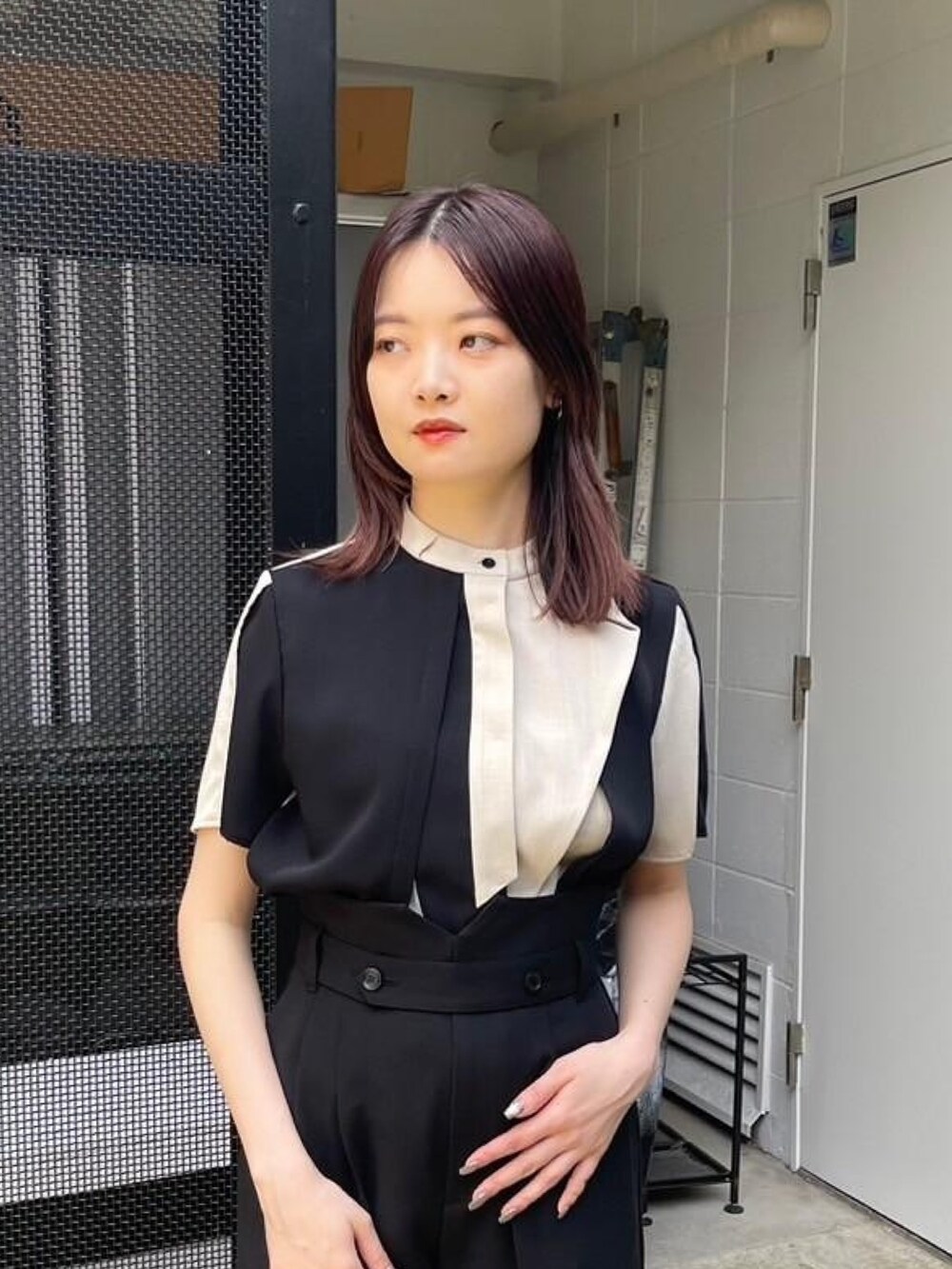 ベージュ系のシャツ/ブラウス、ブラック系のスラックスを着用したレディースの春コーディネートの6枚目の写真