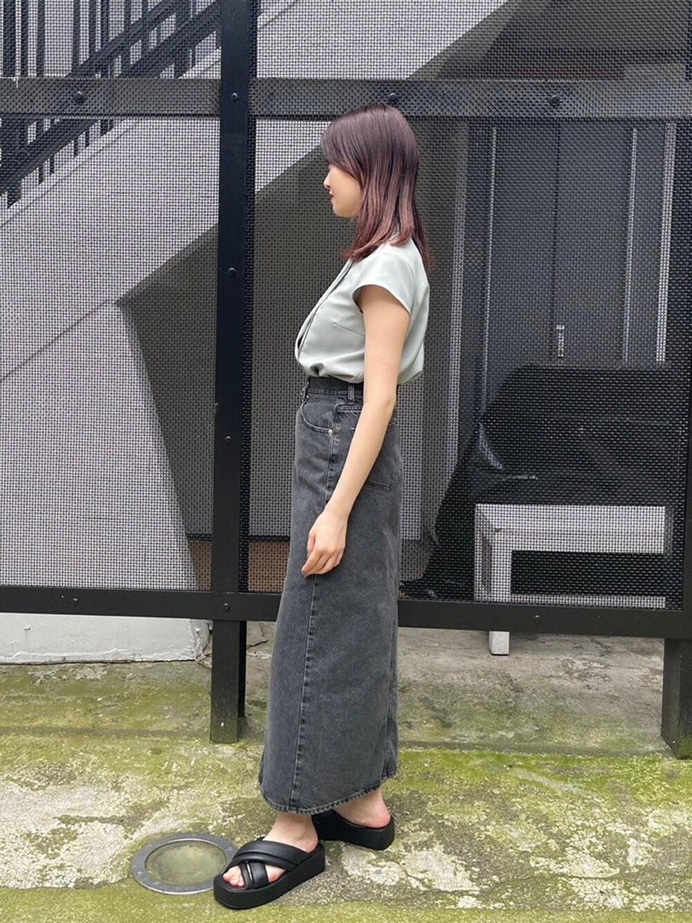 グリーン系のシャツ/ブラウス、ブラック系のデニムスカートを着用したレディースの春コーディネートの2枚目の写真