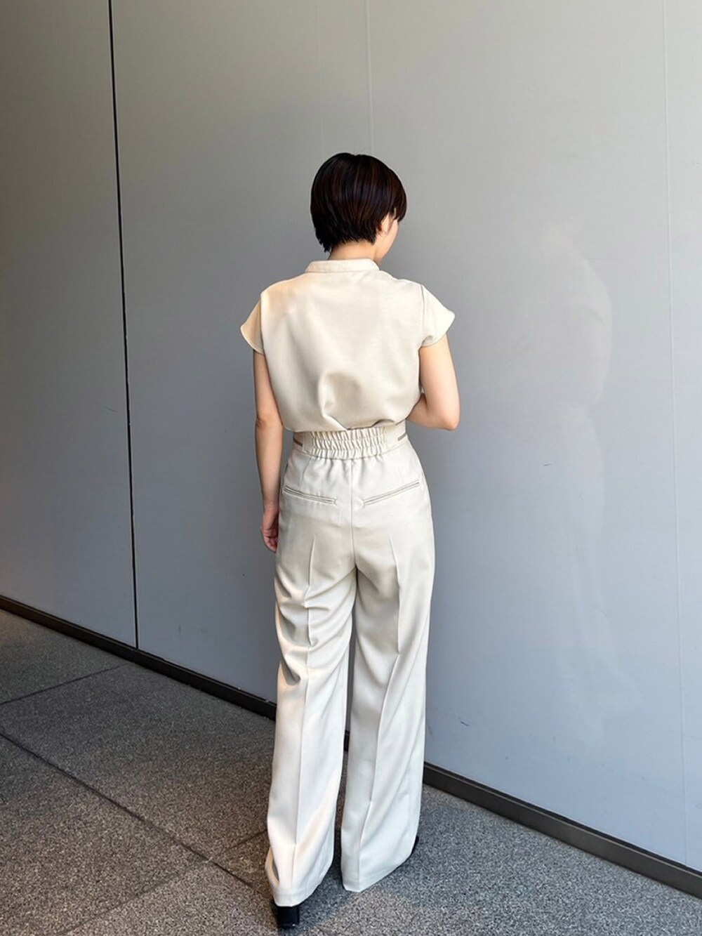 ベージュ系のシャツ/ブラウス、ベージュ系のスラックスを着用したレディースの夏コーディネートの2枚目の写真