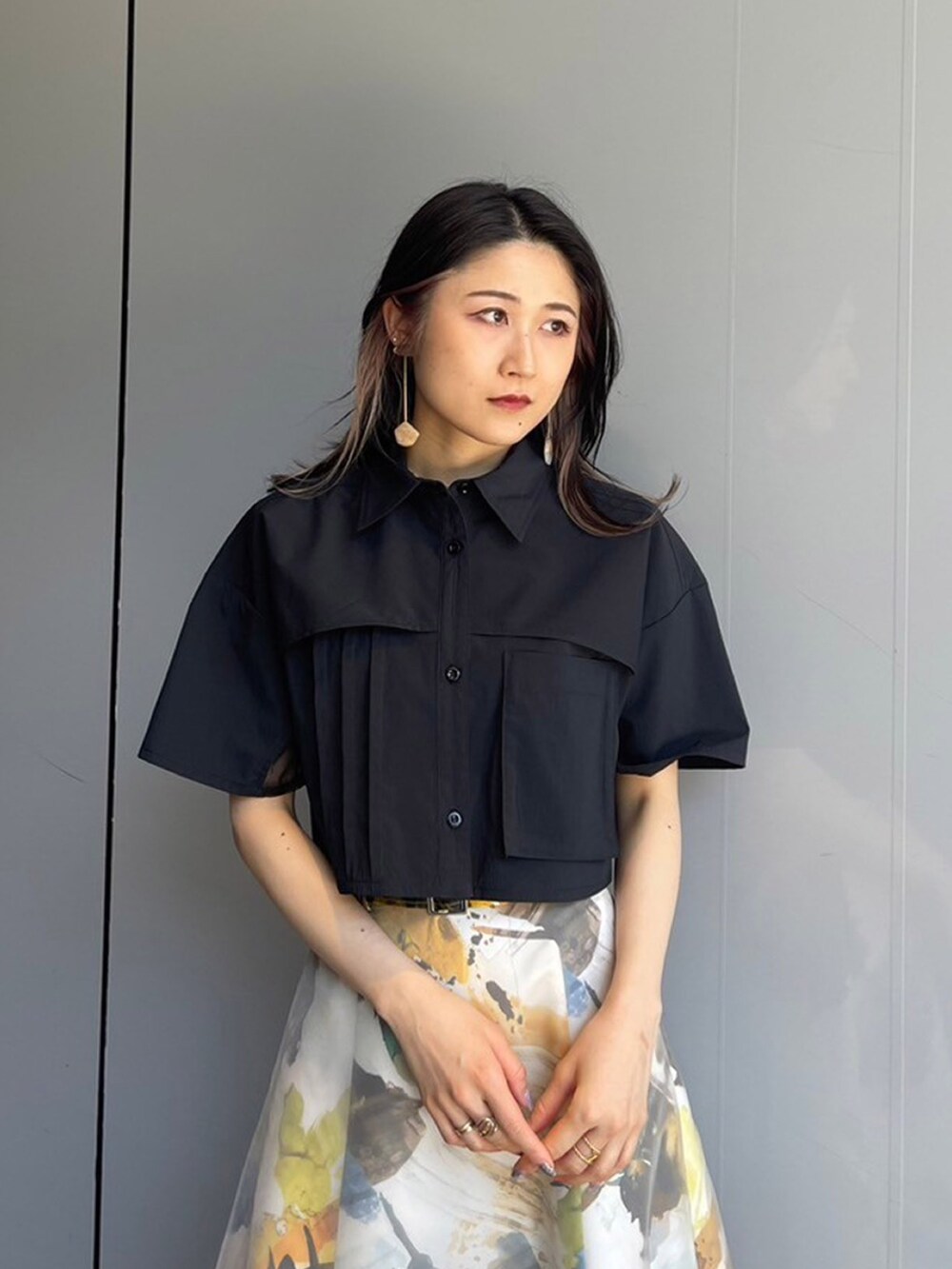 ブラック系のシャツ/ブラウス、イエロー系のスカートを着用したレディースの夏コーディネートの3枚目の写真