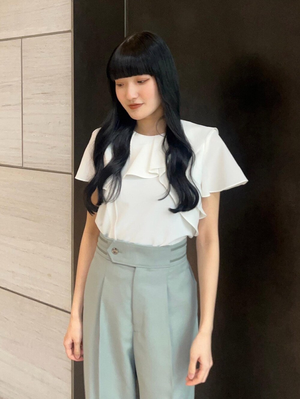 ホワイト系のシャツ/ブラウス、グリーン系のスラックスを着用したレディースの春コーディネートの5枚目の写真