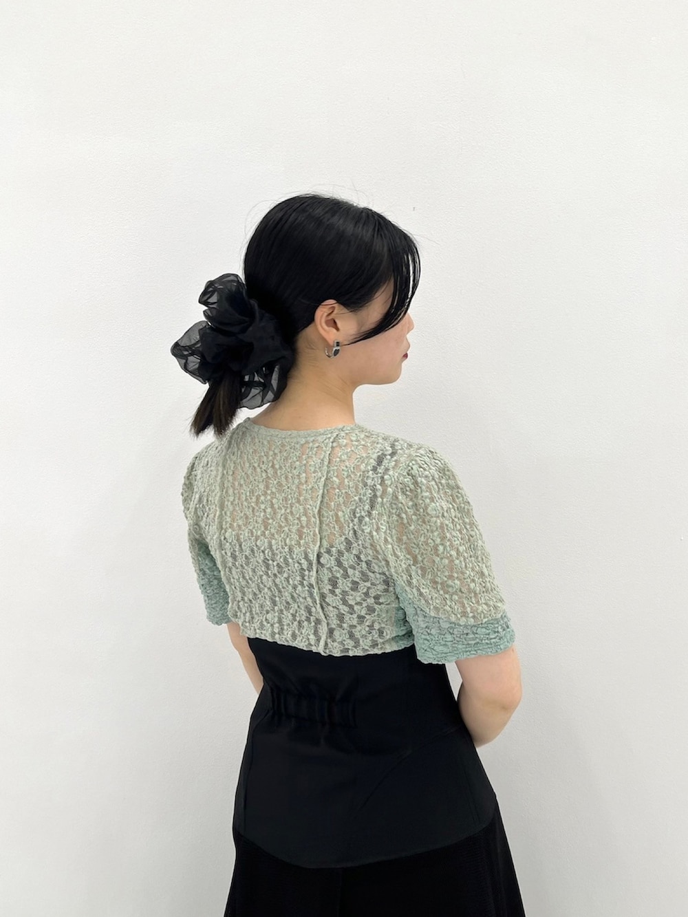 グリーン系のTシャツ/カットソー、ブラック系のスカートを着用したレディースの春コーディネートの6枚目の写真