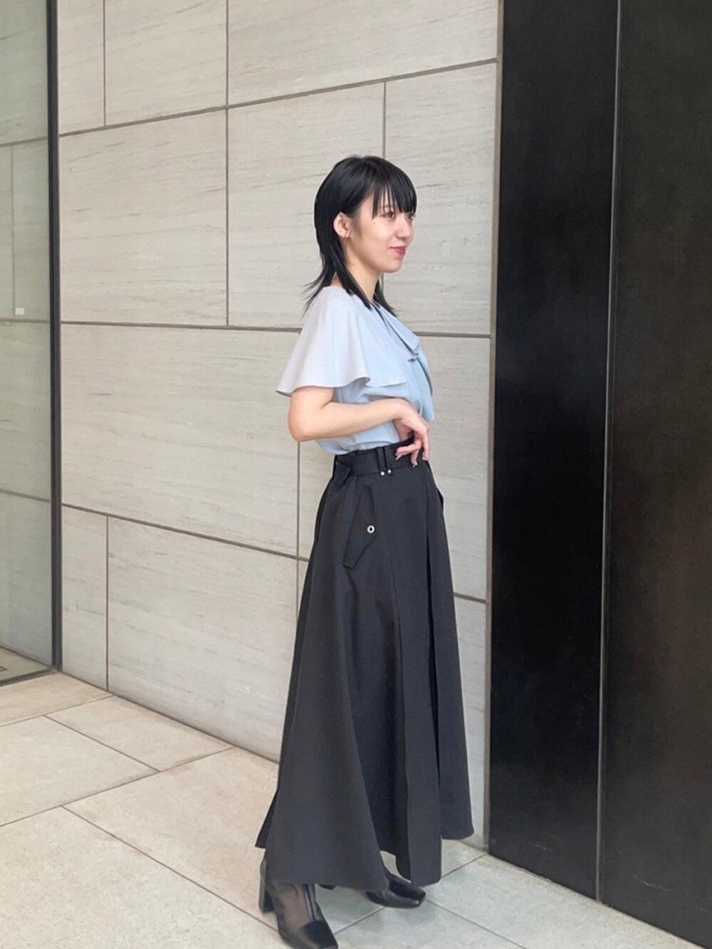 ブルー系のシャツ/ブラウス、ブラック系のスカートを着用したレディースの春コーディネートの4枚目の写真