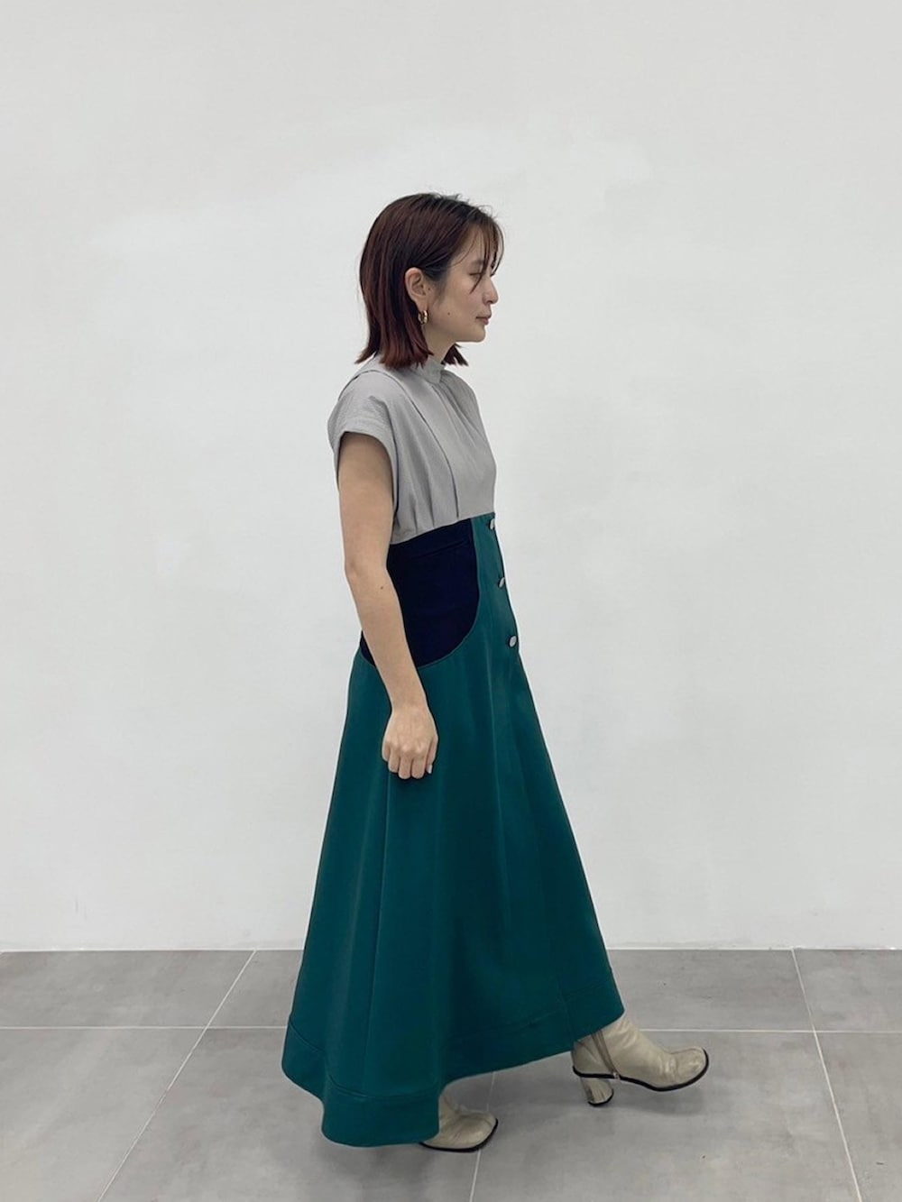 グリーン系のワンピースを着用したレディースの春コーディネートの4枚目の写真