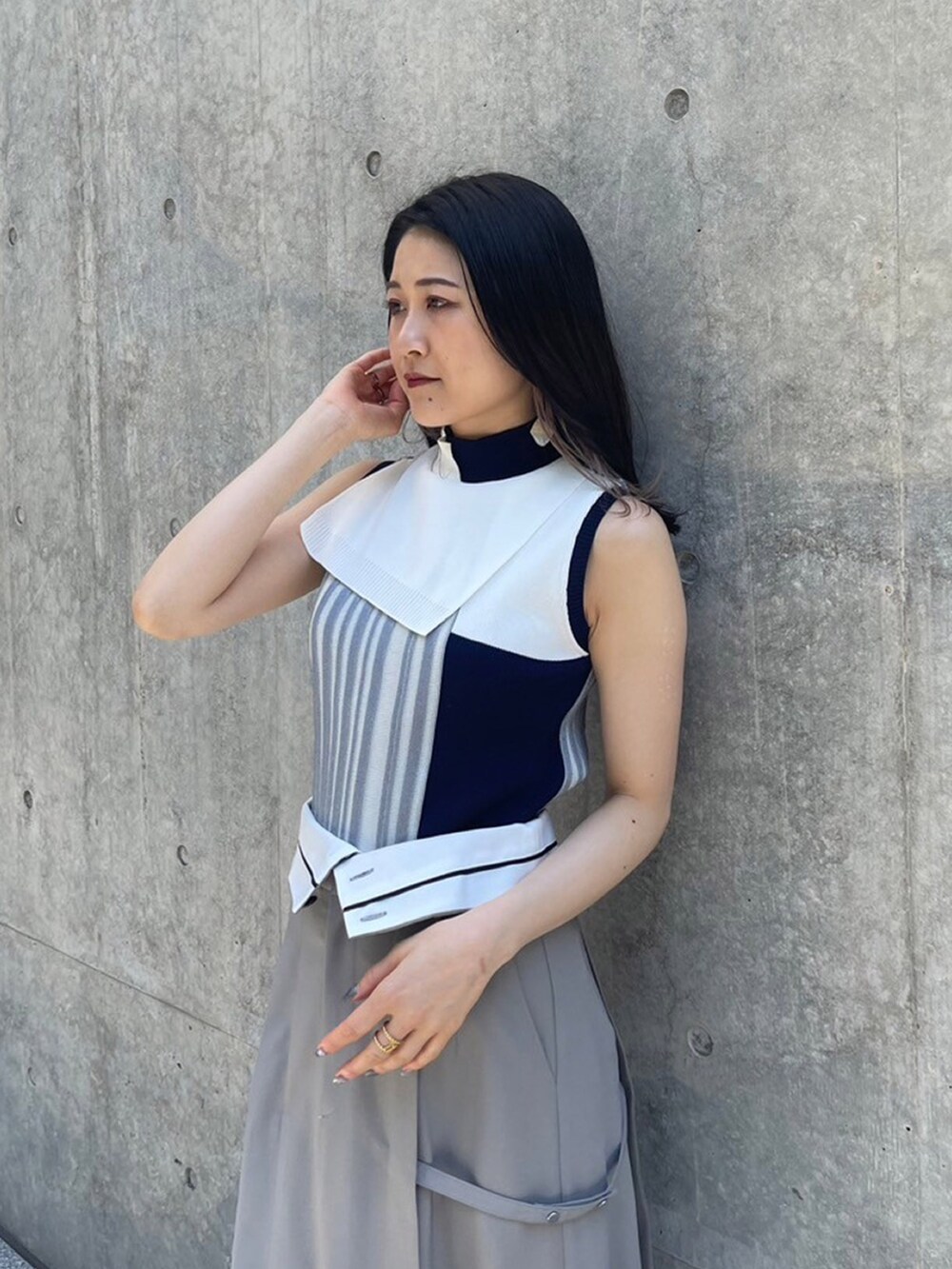 ブルー系のニット/セーター、グレー系のスカートを着用したレディースの夏コーディネートの4枚目の写真