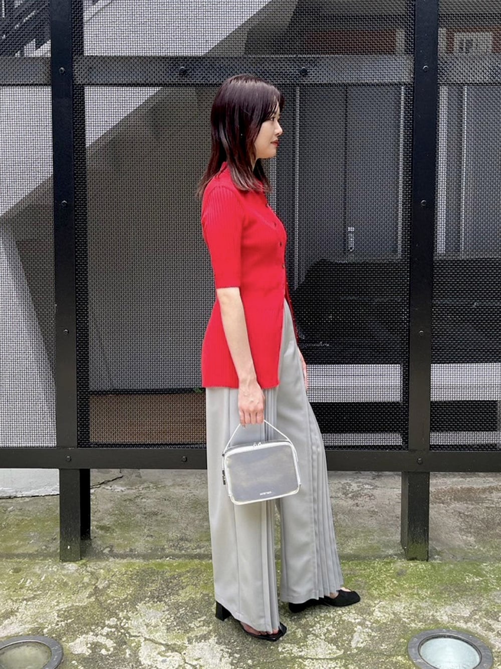 グレー系のその他パンツ、レッド系のニット/セーターを着用したレディースの春コーディネートの4枚目の写真