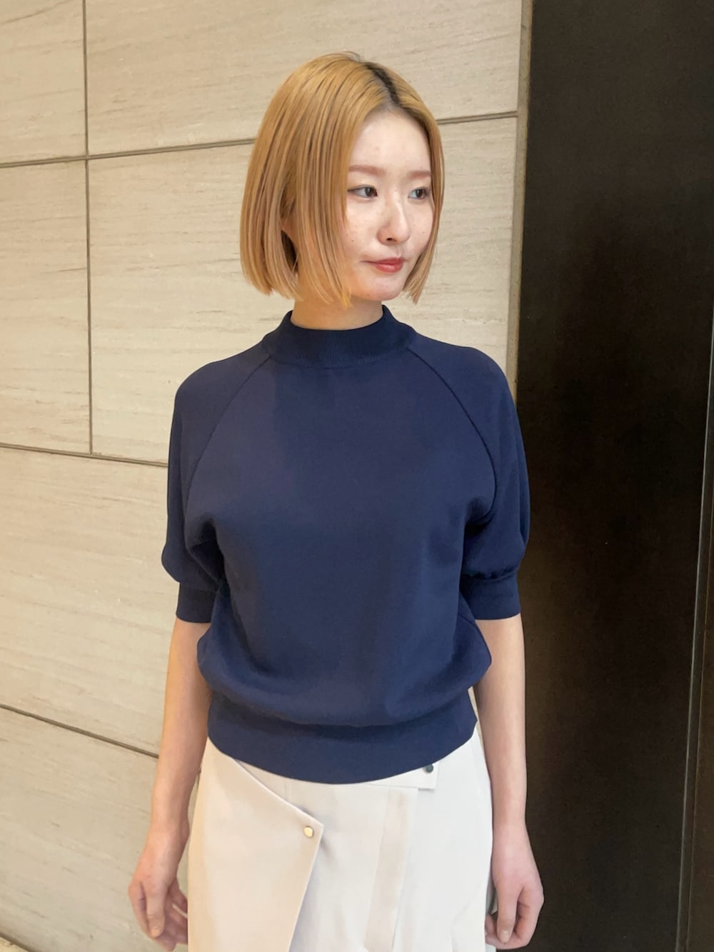 ブルー系のニット/セーター、ベージュ系のスカートを着用したレディースの春コーディネートの4枚目の写真