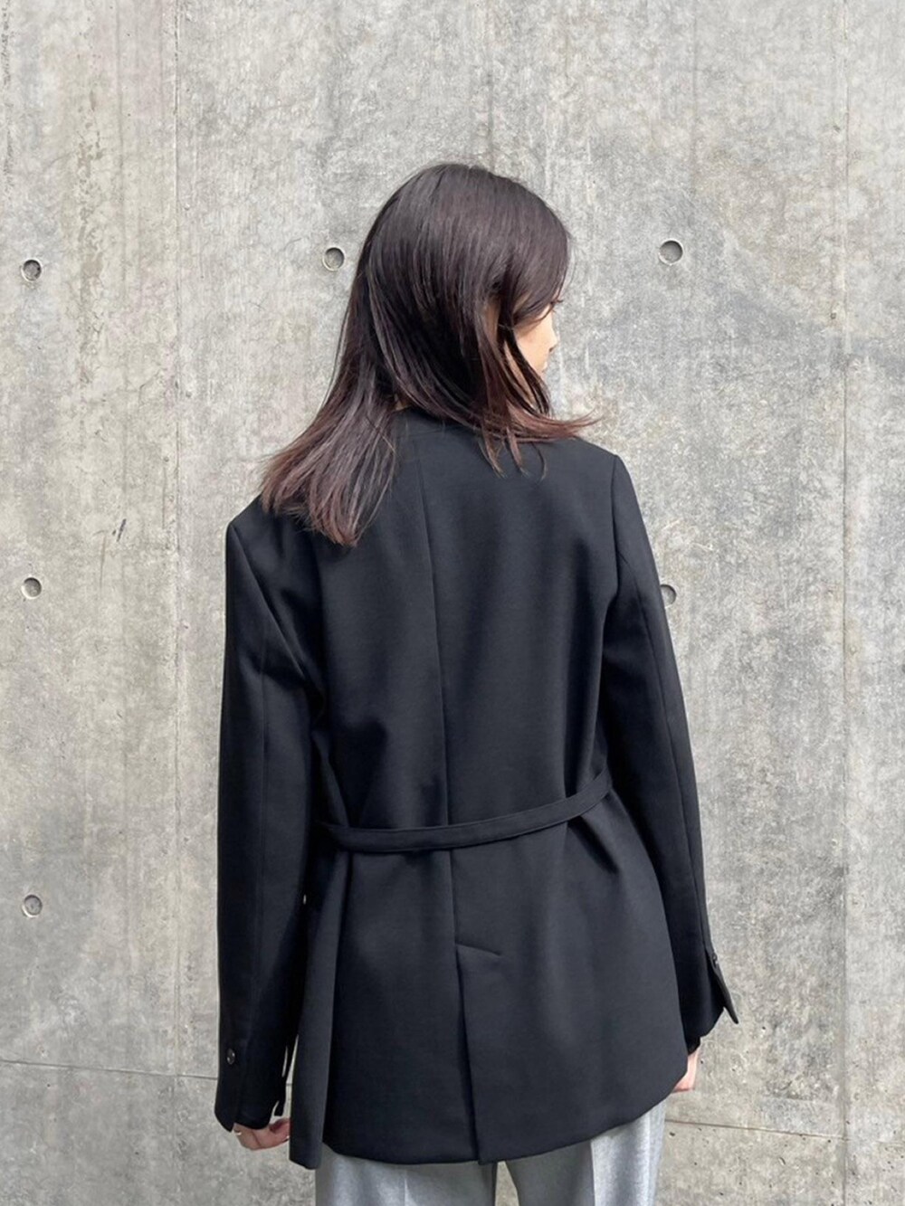 ブラック系のテーラードジャケット、グレー系のその他パンツを着用したレディースの秋コーディネートの6枚目の写真