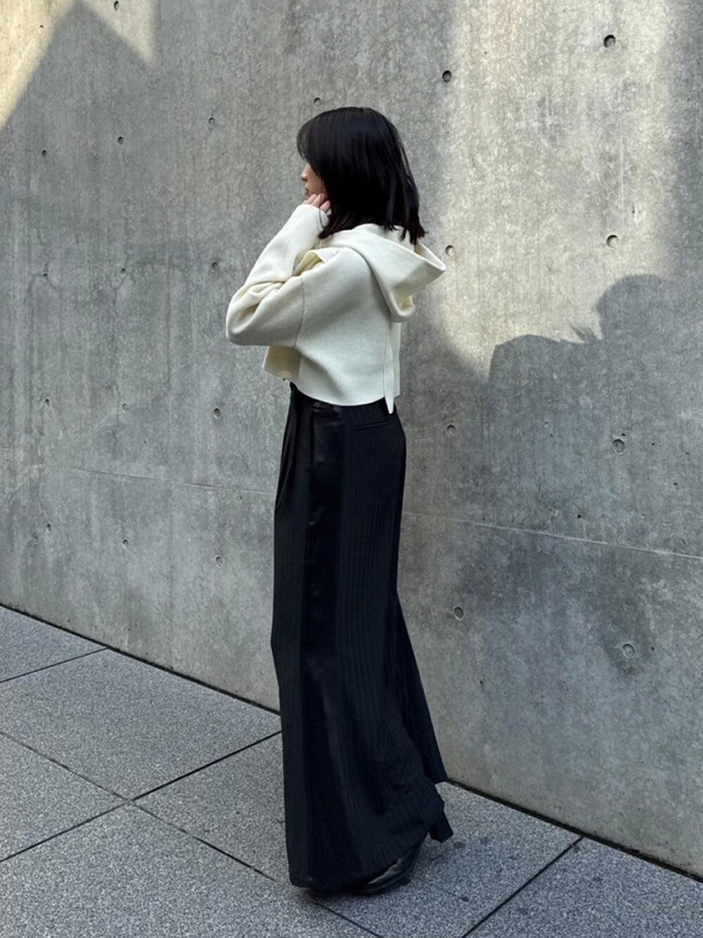 ホワイト系のニット/セーター、ブラック系のその他パンツを着用したレディースの秋コーディネートの2枚目の写真