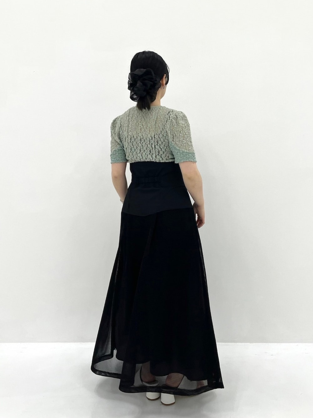 グリーン系のTシャツ/カットソー、ブラック系のスカートを着用したレディースの春コーディネートの4枚目の写真