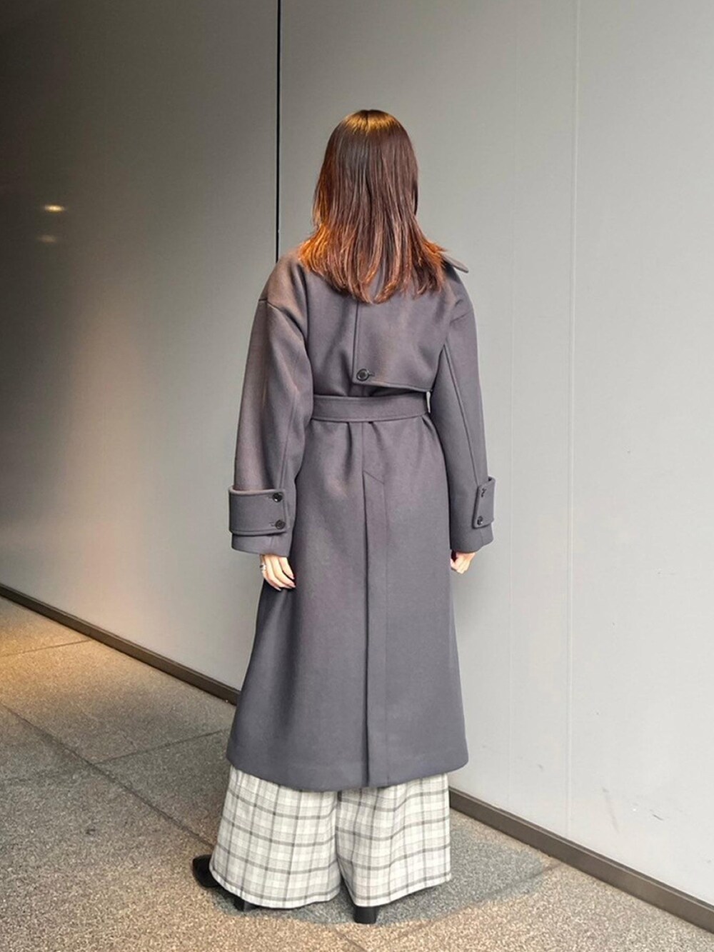 グレー系のステンカラーコートを着用したレディースの秋コーディネートの3枚目の写真