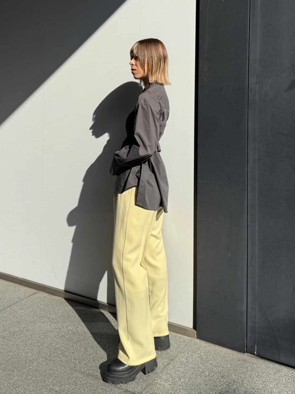 グレー系のシャツ/ブラウス、イエロー系のスラックスを着用したレディースの秋コーディネートの2枚目の写真