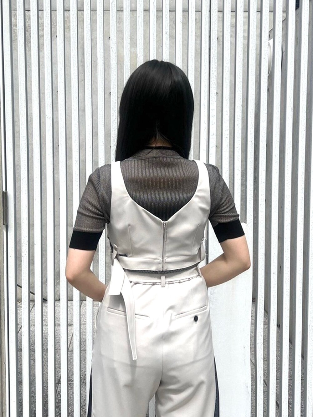 ゴールド系のニット/セーター、ベージュ系のベスト、ベージュ系のその他パンツを着用したレディースの春コーディネートの6枚目の写真