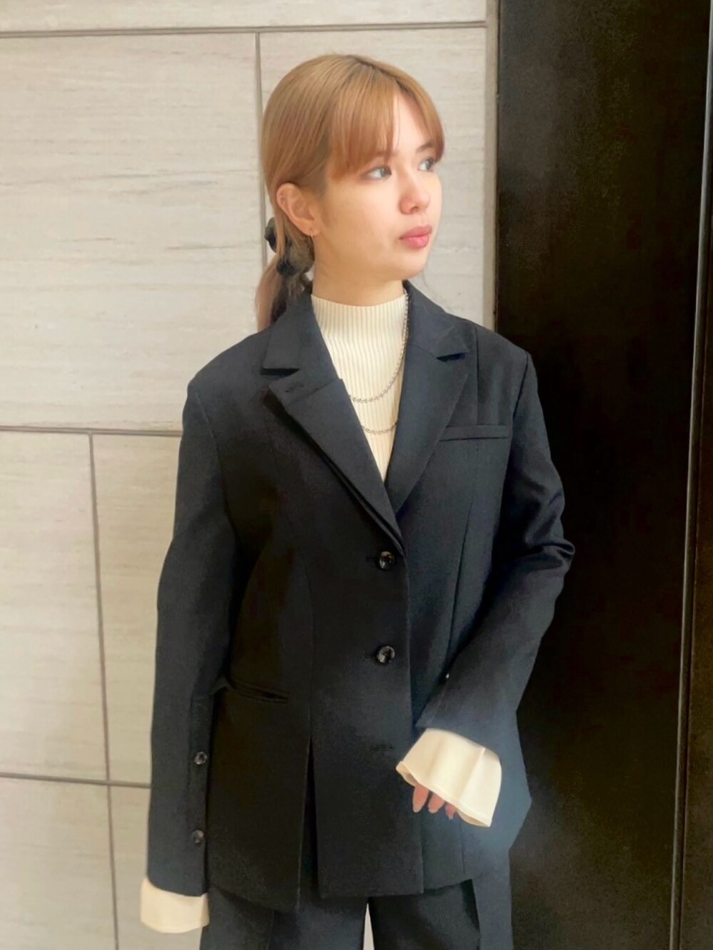 ブラック系のテーラードジャケット、ブラック系のその他パンツを着用したレディースの春コーディネートの4枚目の写真