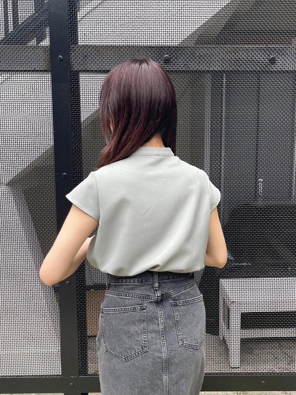 グリーン系のシャツ/ブラウス、ブラック系のデニムスカートを着用したレディースの春コーディネートの6枚目の写真