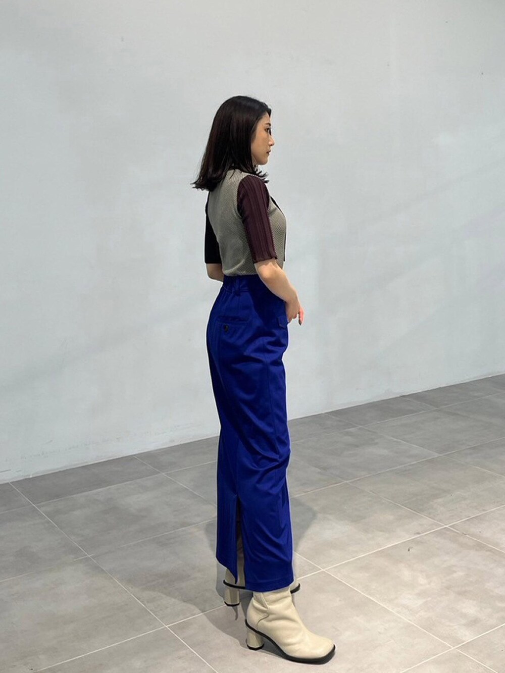 ブラウン系のニット/セーター、ブルー系のスカートを着用したレディースの秋コーディネートの2枚目の写真