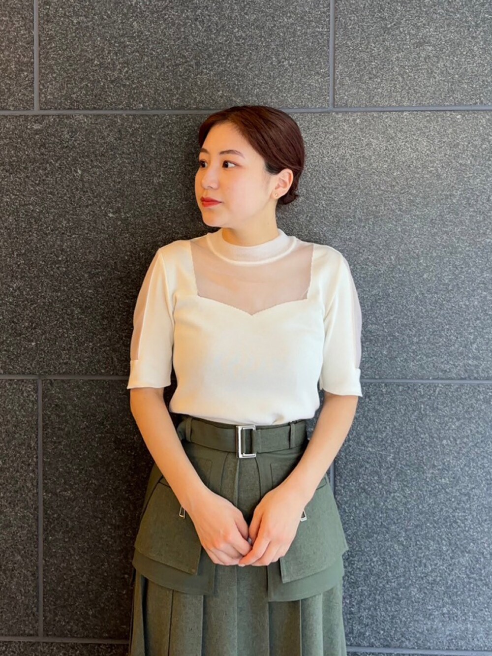 ホワイト系のニット/セーター、グリーン系のスカートを着用したレディースの夏コーディネートの4枚目の写真