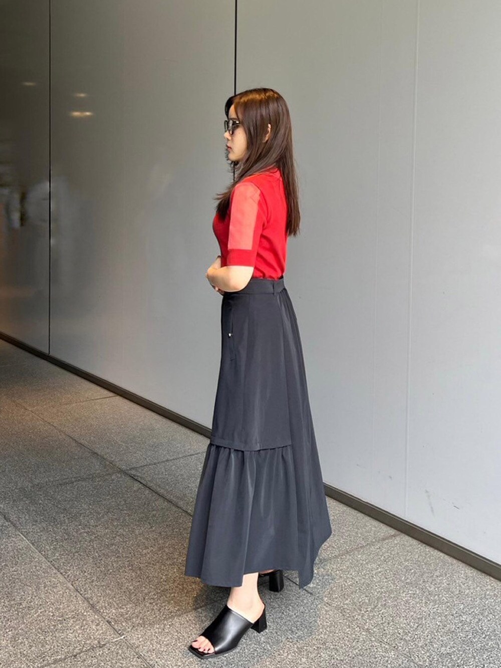 レッド系のニット/セーター、ブラック系のスカートを着用したレディースの夏コーディネートの2枚目の写真