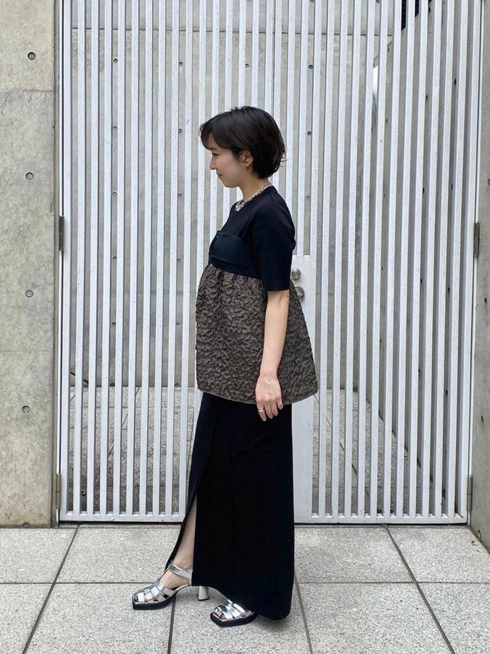 グリーン系のキャミソールを着用したレディースの春コーディネートの2枚目の写真