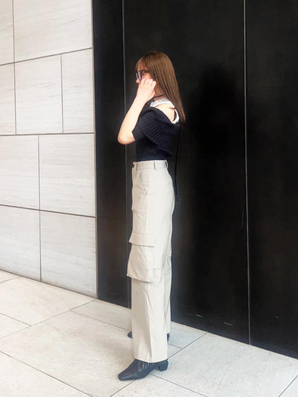 ベージュ系のカーゴパンツ、ブラック系のニット/セーターを着用したレディースの春コーディネートの2枚目の写真