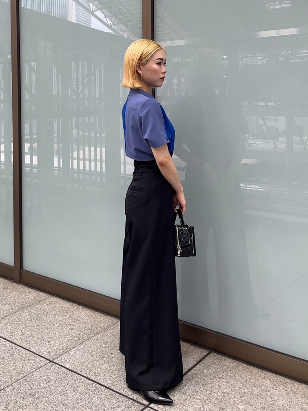ブルー系のシャツ/ブラウス、ブラック系のスラックスを着用したレディースの夏コーディネートの2枚目の写真