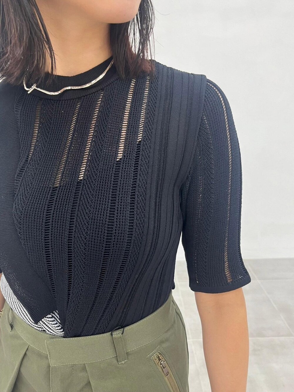 ブラック系のニット/セーター、グリーン系のカーゴパンツを着用したレディースの秋コーディネートの5枚目の写真