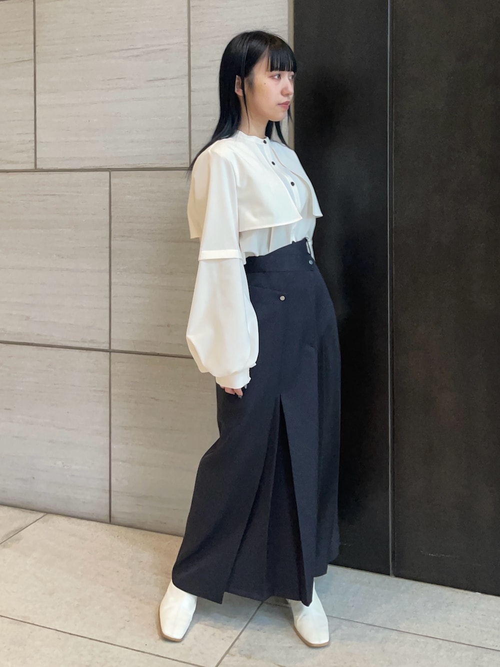 ベージュ系のシャツ/ブラウス、ブラック系のスカートを着用したレディースの春コーディネートの2枚目の写真