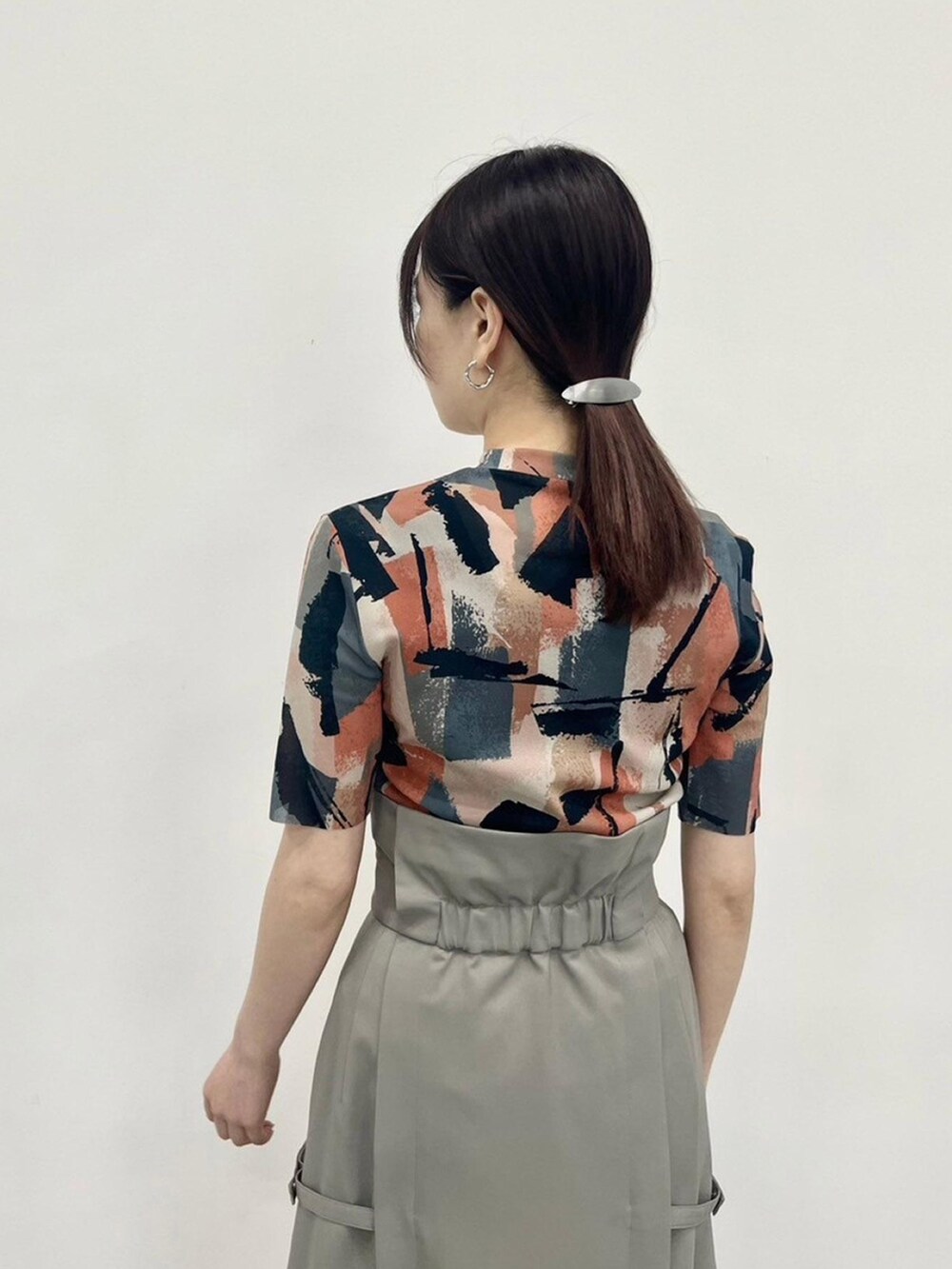 ベージュ系のTシャツ/カットソー、グレー系のスカートを着用したレディースの春コーディネートの7枚目の写真