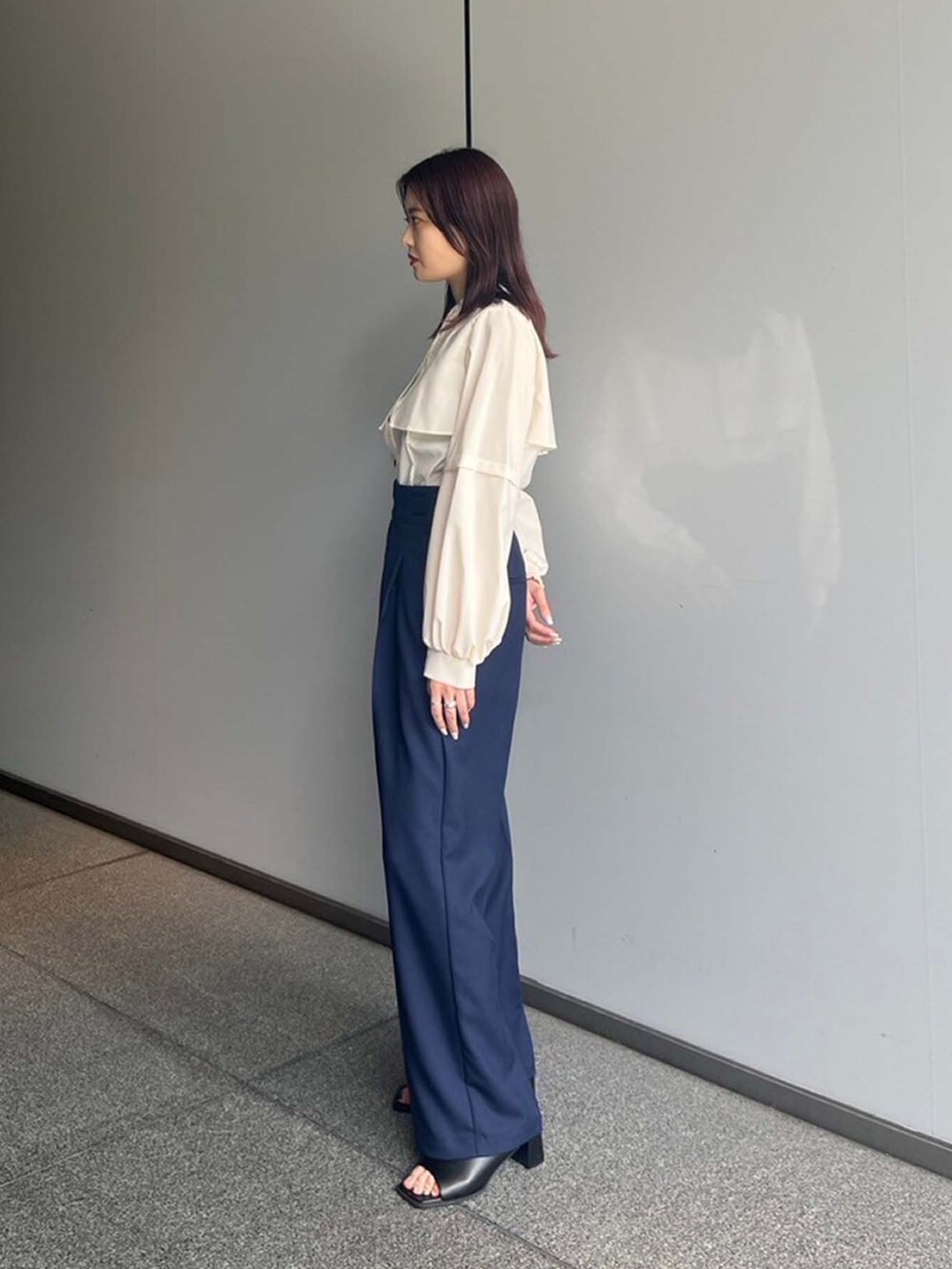 ベージュ系のシャツ/ブラウス、ブルー系のスラックスを着用したレディースの夏コーディネートの2枚目の写真