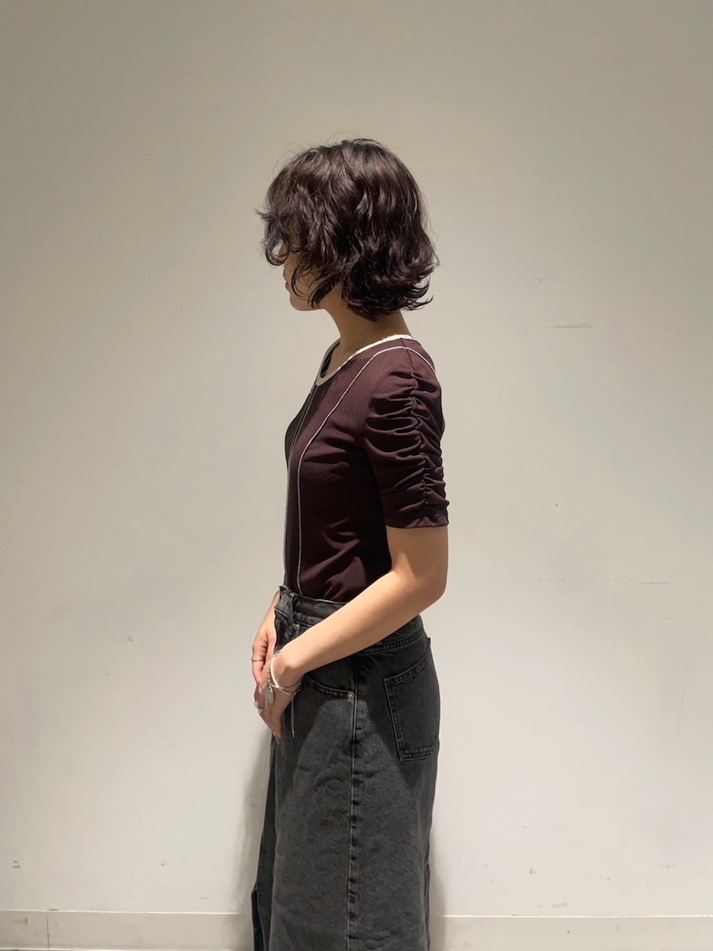 ブラウン系のTシャツ/カットソー、ブラック系のデニムスカートを着用したレディースの夏コーディネートの4枚目の写真