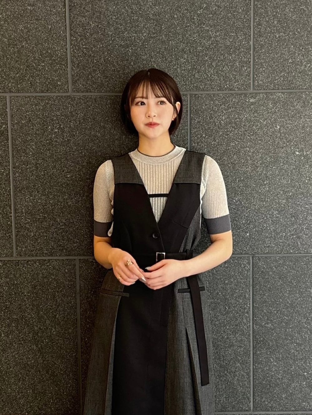 シルバー系のニット/セーター、ブラック系のジャンパースカートを着用したレディースの夏コーディネートの3枚目の写真