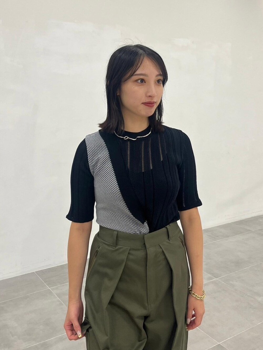 ブラック系のニット/セーター、グリーン系のカーゴパンツを着用したレディースの秋コーディネートの4枚目の写真