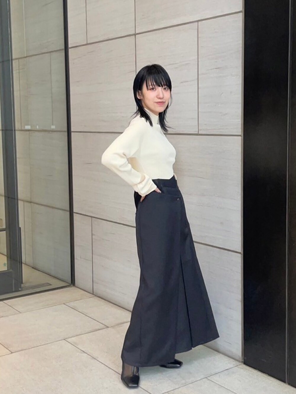 ベージュ系のニット/セーター、ブラック系のスカートを着用したレディースの春コーディネートの4枚目の写真