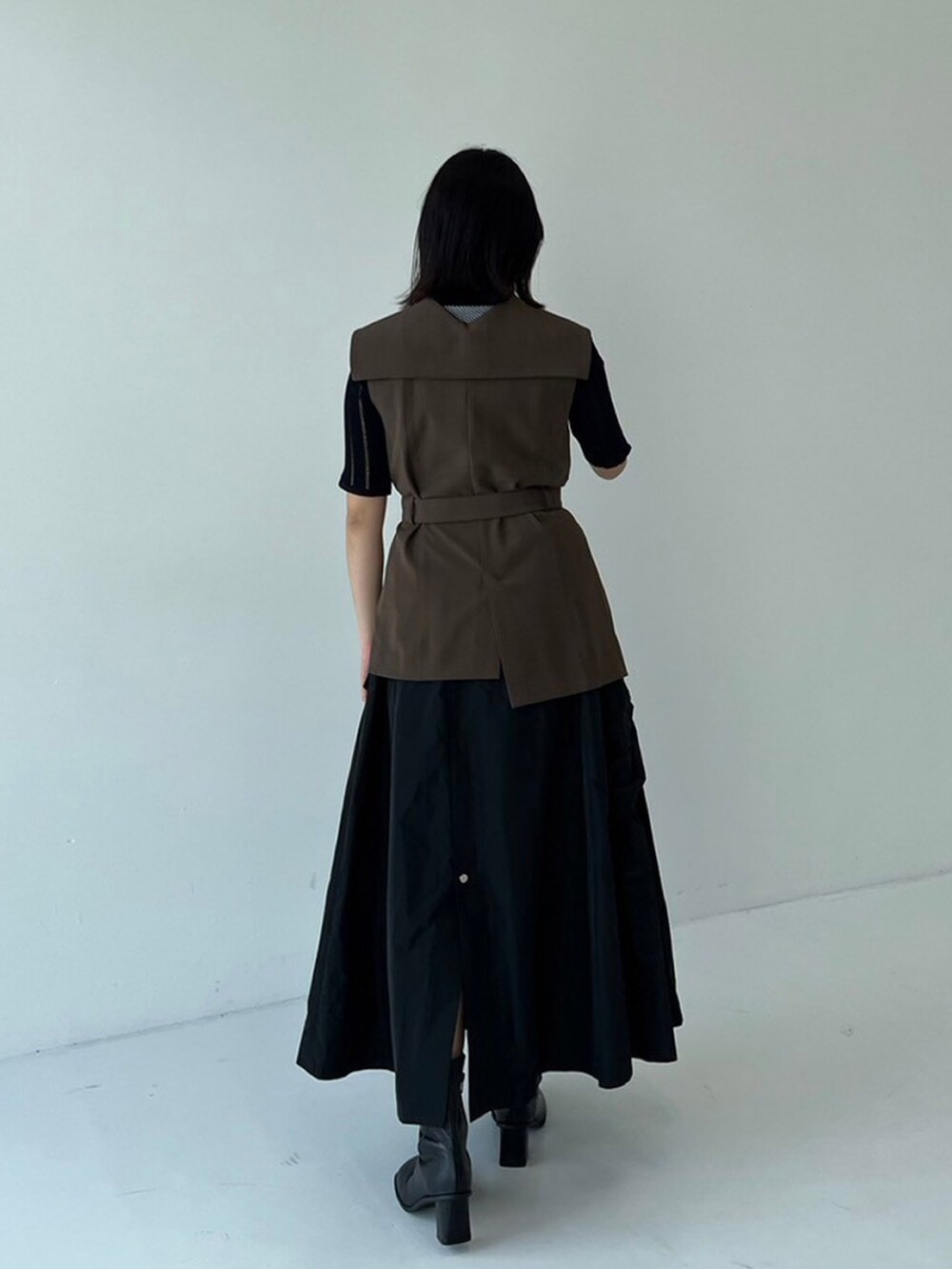 ブラック系のスカート、ブラウン系のテーラードジャケット、ブラック系のニット/セーターを着用したレディースの秋コーディネートの3枚目の写真