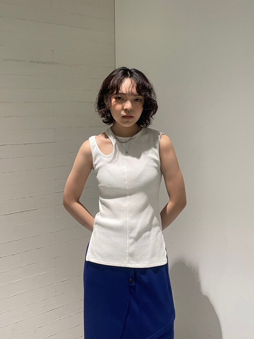 ホワイト系のタンクトップ、ブルー系のスカートを着用したレディースの夏コーディネートの4枚目の写真