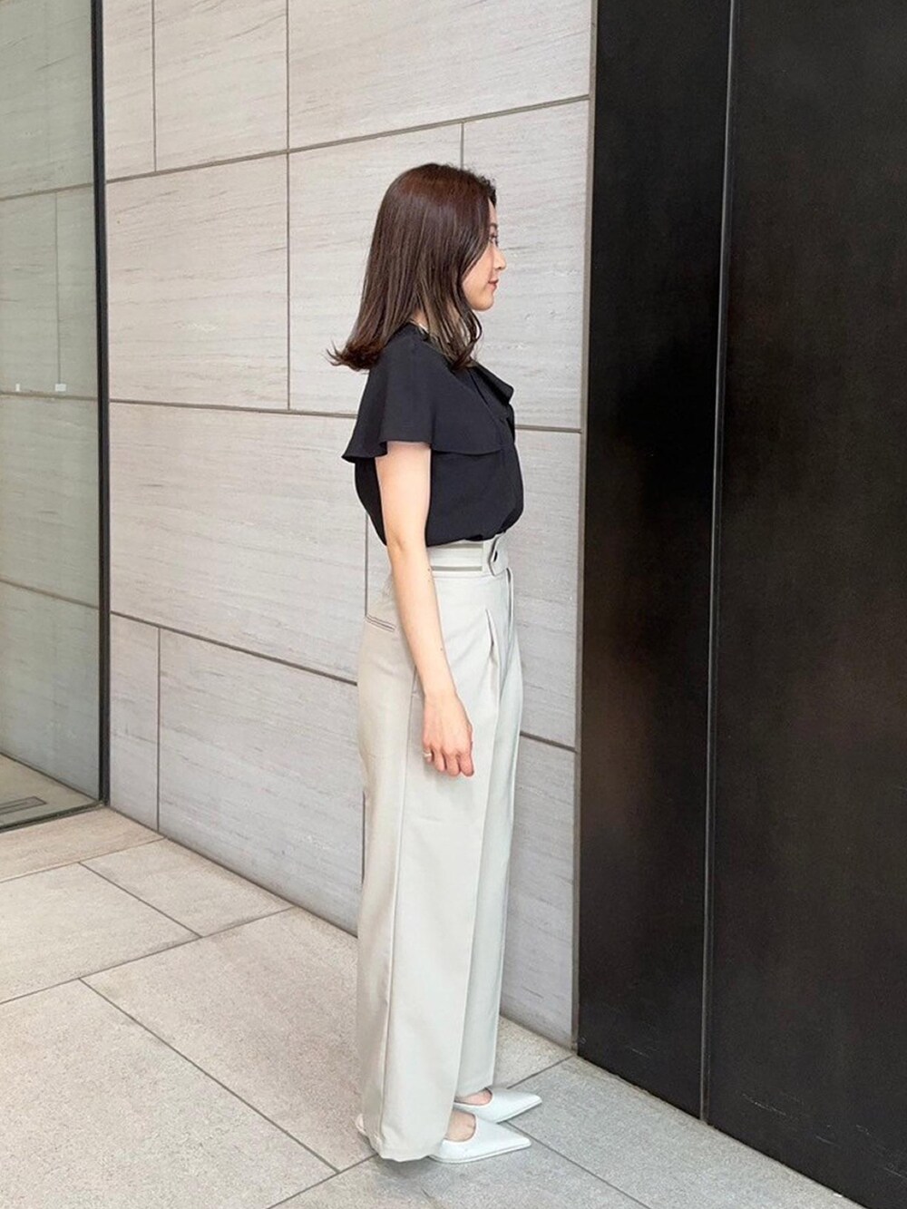 ブラック系のシャツ/ブラウス、ベージュ系のスラックスを着用したレディースの春コーディネートの4枚目の写真