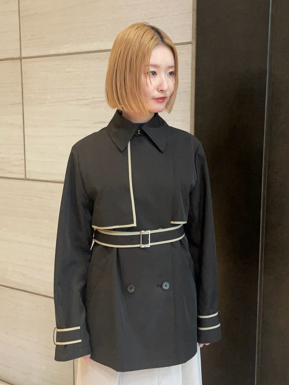 ブラック系のトレンチコートを着用したレディースの春コーディネートの5枚目の写真