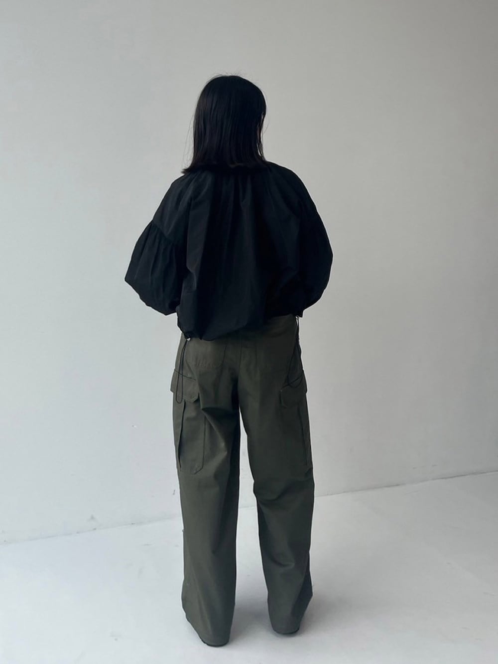 ブラック系のブルゾン、グリーン系のカーゴパンツを着用したレディースの秋コーディネートの2枚目の写真