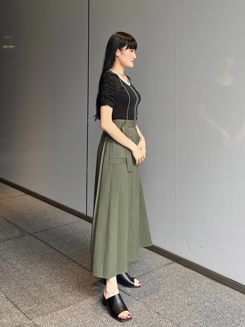 ブラック系のTシャツ/カットソー、グリーン系のスカートを着用したレディースの夏コーディネートの2枚目の写真