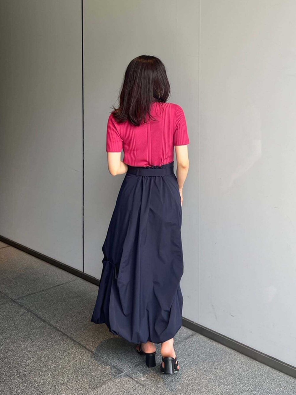 ピンク系のポロシャツ、ブルー系のスカートを着用したレディースの夏コーディネートの3枚目の写真