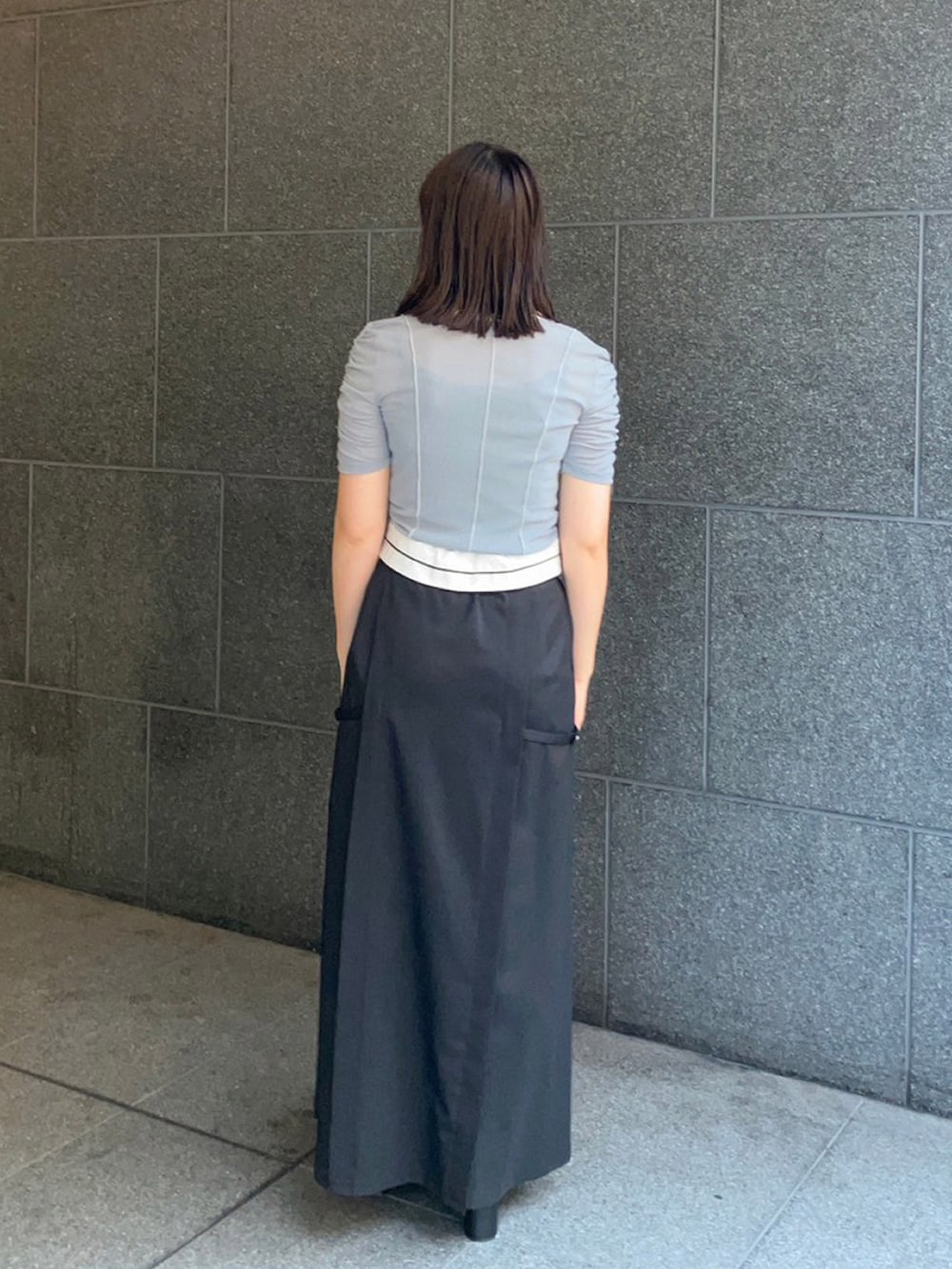 グリーン系のTシャツ/カットソー、ブラック系のスカートを着用したレディースの夏コーディネートの2枚目の写真