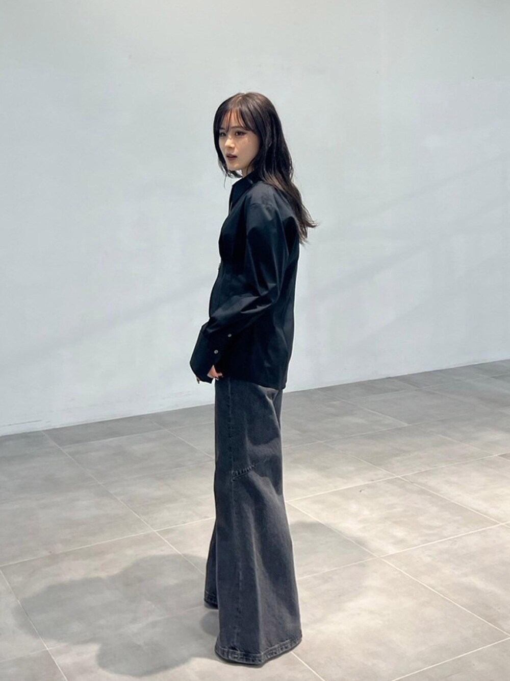 ブラック系のシャツ/ブラウス、ブラック系のデニムパンツを着用したレディースの秋コーディネートの2枚目の写真